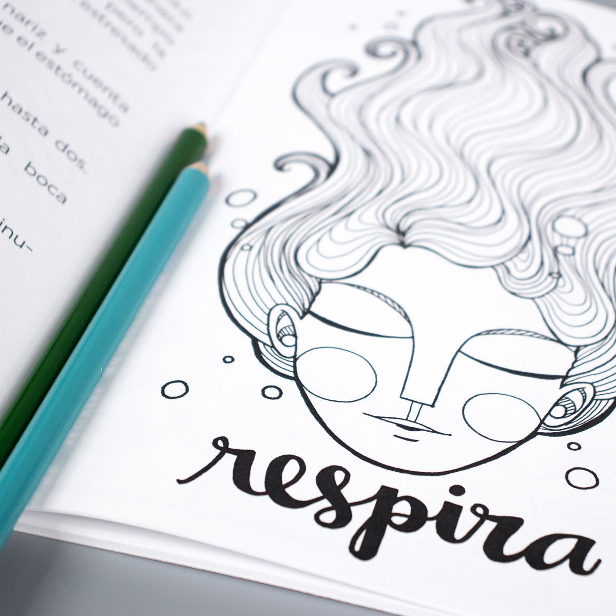 A page inside of Artisticamente Valiente shows a woman's face with her eyes closed and the word "respira" which means "breathe".